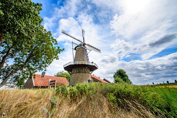 Die Hompesche Mühle an einem bewölkten Sommertag mit einem Herrn, der ein Foto von der Mühle macht
