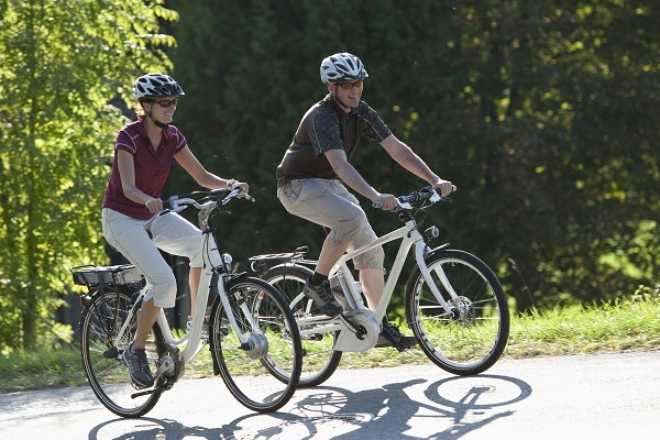 Koppel fietst over een heuveltje met de e-bikes