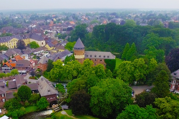 Luchtfoto van de burcht van Brüggen, omringd door groen en gelegen in het centrum van het stadje.