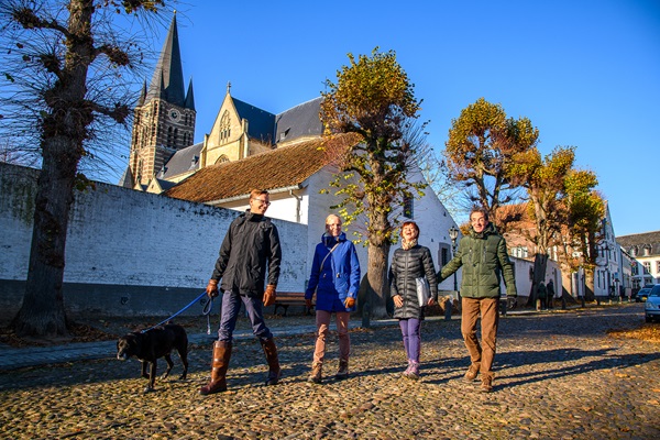 wandelaars lopen met de hond door het centrum van Thorn in het najaar