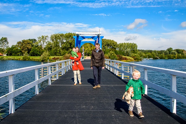 Gezin wandelt op de brug over de Maasplassen in de gemeente Maasgouw