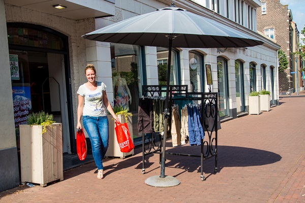 Woman comes out of shop with two shopping bags
